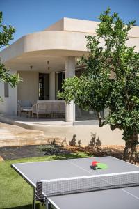a ping pong table in front of a house at Villa Portokalea in Maleme +73 photos