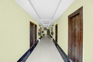 an empty corridor of a building with wooden doors at Super Hotel O Kashi Ghat Varanasi Formerly Ganga Valley in Rāmnagar