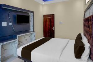 a bedroom with a bed and a flat screen tv at Super Hotel O Kashi Ghat Varanasi Formerly Ganga Valley in Rāmnagar +35 photos