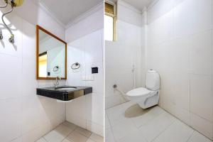a white bathroom with a sink and a toilet at Collection O Charbagh Metro Station Lucknow Formerly Seven Seas in Lucknow
