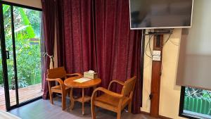 a room with a table and chairs and a television at 88 Homestay in Bang Chak