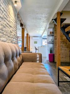 a couch in a living room with a brick wall at Apartments 18 - Central & Cozy in Velingrad