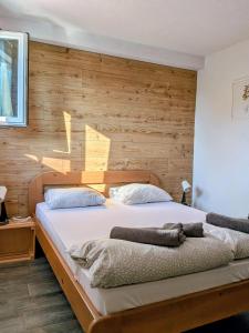 a bedroom with a large bed with a wooden wall at Apartments 18 - Central & Cozy in Velingrad