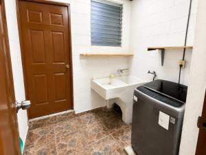 a bathroom with a sink and a bath tub at Gosen Stays in Antiguo Cuscatlán +5 photos