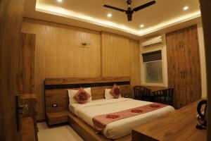 a bedroom with a bed and a ceiling fan at Hotel Parth Inn in Haldwāni