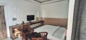 a small room with a couch and a television at Hotel Parth Inn in Haldwāni