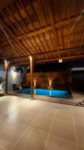 a swimming pool under a wooden roof with a pool at Nara Housee' in Darmasaba