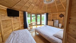 a room with two beds and a television in a cabin at Близняшки in Kaji-Say