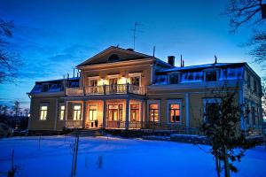 a large house with its lights on at night at Mukkulan kartano in Lahti +16 photos
