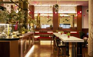 a restaurant with a bar with tables and chairs at Hyatt Centric Gran Via Madrid in Madrid