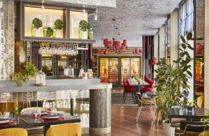 a restaurant with a bar and tables and chairs at Hyatt Centric Gran Via Madrid in Madrid