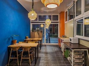 a dining room with tables and chairs and blue walls at Beachblue Pension Geoje in Geoje