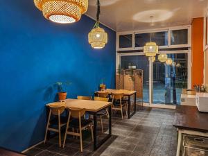 a restaurant with tables and chairs in a blue wall at Beachblue Pension Geoje in Geoje