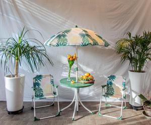 a table with a vase of flowers and two chairs at Beachblue Pension Geoje in Geoje +8 photos
