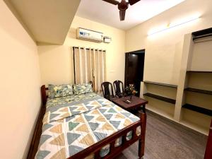 a bedroom with a bed and a table and chairs at Serinity Saral in Pondicherry +10 photos