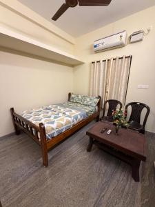 a bedroom with a bed and a coffee table at Serinity Saral in Pondicherry