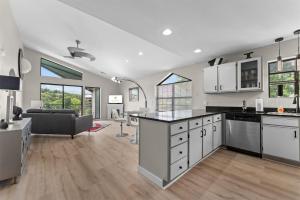 a kitchen with white cabinets and a living room at Green Mountain Getaway 2BDR in Branson