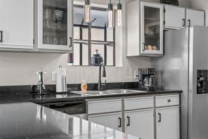 a kitchen with white cabinets and a black counter top at Green Mountain Getaway 2BDR in Branson +19 photos