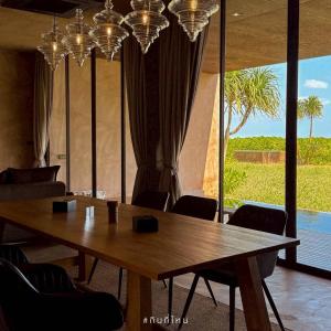 a conference room with a wooden table and chairs at inchantreedoolay huahin in Pran Buri