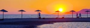 a group of people standing on a beach with umbrellas at Vanilla House in Ulcinj
