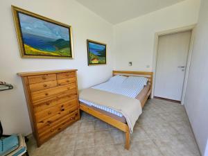 a small bedroom with a bed and a dresser at Villa Rolla in Tivat