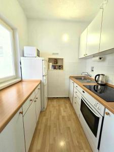 a kitchen with white appliances and a wooden counter top at Garden House Tučepi in Tučepi