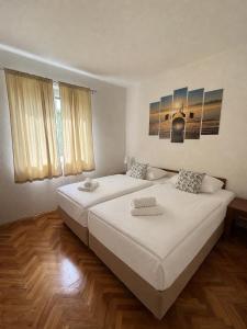 two beds in a bedroom with two windows at Garden House Tučepi in Tučepi