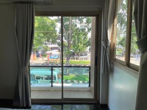 a window with a view of a pool at The Kanee Hostel in Nakhon Phanom