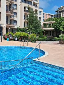 a large blue swimming pool in front of a building at Студио Стайл - Соренто Соле Маре in Sveti Vlas