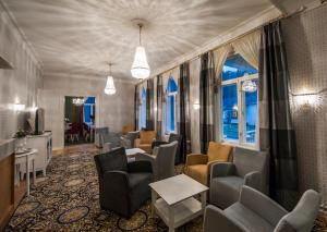 a waiting room with chairs and tables and a tv at Mukkulan kartano in Lahti