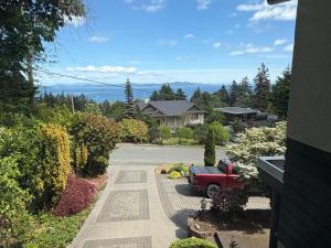 a driveway with a red truck parked in a yard at Cozy Ocean View Retreat in Victoria