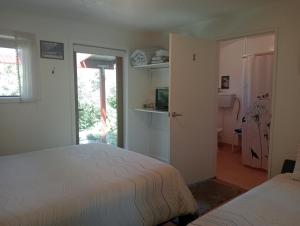 a bedroom with two beds and a door to a room at Rata Lodge Accommodation in Otira +5 photos