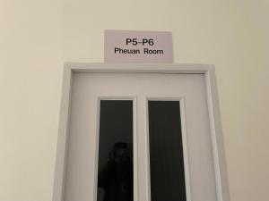 a sign on top of a white door at The Kanee Hostel in Nakhon Phanom