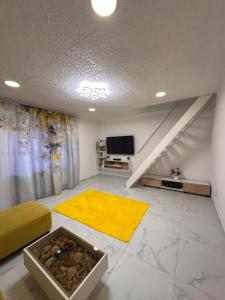a living room with a tv and a yellow rug at Casa Happy in Petroşani