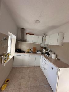 a kitchen with white cabinets and white appliances at Casa Happy in Petroşani