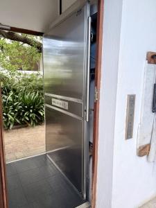 a stainless steel refrigerator sitting inside of a door at Private Retreat in Gordonʼs Bay