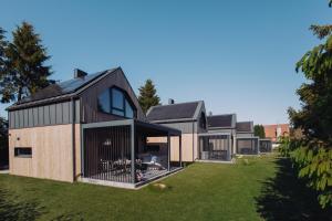 a contemporary house with a black roof at BiałogóraChill 11B Całoroczne Spa i Active in Białogóra