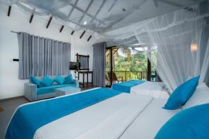 a bedroom with two beds and a balcony at Ella Blue Heaven in Ella