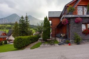 a bench sitting outside of a house with mountains in the background at Drevenica u Pavla in Ždiar