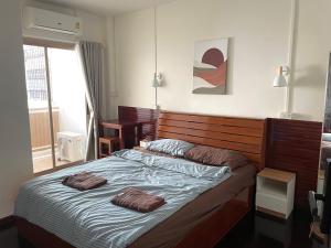a bedroom with a bed with two pillows on it at The Kanee Hostel in Nakhon Phanom