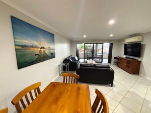 a living room with a couch and a table at Jubilee Apartment 08 - Bring your own linen in South West Rocks
