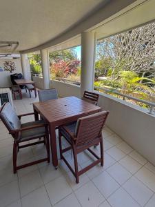 a dining room with a table and chairs and two windows at Jubilee Apartment 08 - Bring your own linen in South West Rocks