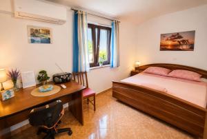 a bedroom with a desk and a bed and a desk at Apartment RB in Omišalj