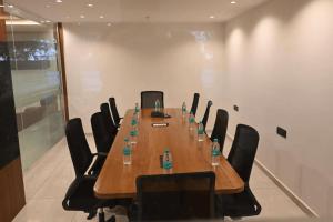 a conference room with a long wooden table and chairs at Good One Suites Near Manyata Tech Park in Bangalore