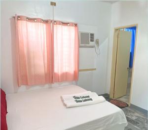 a hospital room with a bed with a window and a towel at Villa Sabang in Puerto Galera