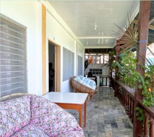 a porch with a couch and a table on a balcony at Villa Sabang in Puerto Galera