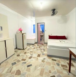 a living room with a bed and a kitchen at Villa Sabang in Puerto Galera