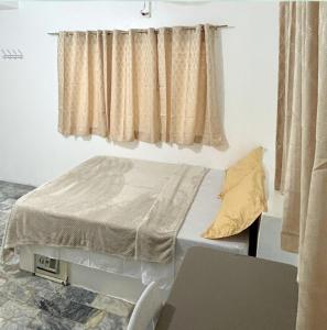 a small bed in a room with a window at Villa Sabang in Puerto Galera