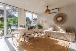a living room with a couch and a table and chairs at Casa das Flores by Hostiva in Aroeira