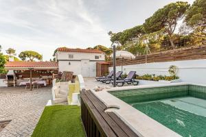 a backyard with a swimming pool and a house at Casa das Flores by Hostiva in Aroeira